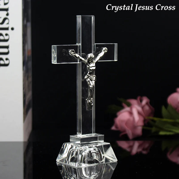 Clear crystal cross statue with silver-tone Jesus figure on a reflective base, displayed against a dark background