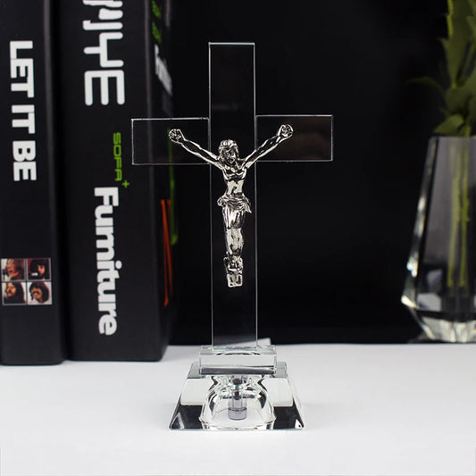 Crystal cross with Jesus figure on a stand in front of books