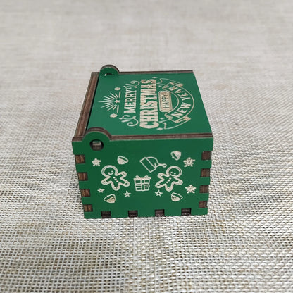 Green wooden box with Christmas-themed decorations on a textured fabric background