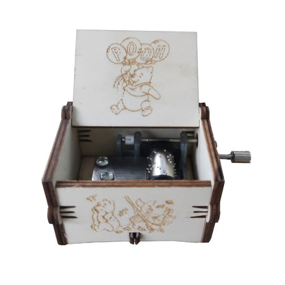 Open wooden Christmas music box with festive Merry Christmas artwork and visible hand-crank mechanism