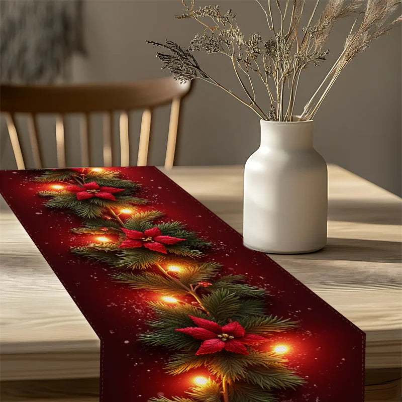 Decorative Christmas table runner with lights and poinsettias on a wooden table.