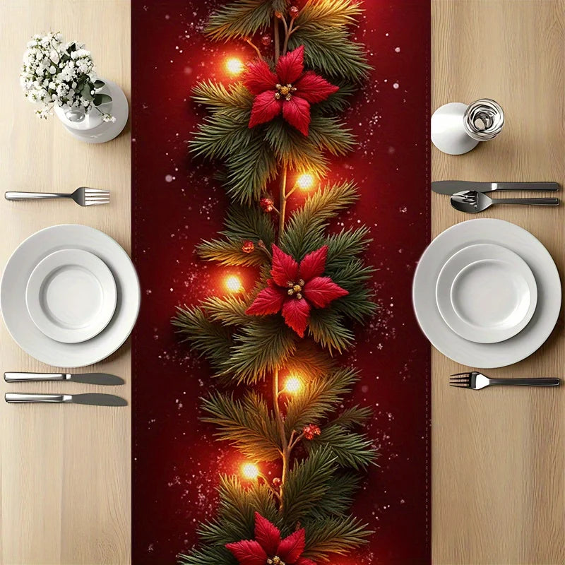 Christmas-themed table setting with poinsettias, lights, and greenery on a red runner.
